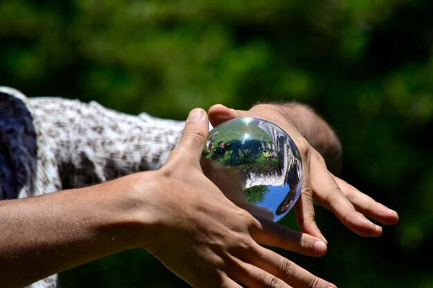 Foto bola de cristal o bola de contacto acto de malabarismo con la bola de acrílico o de cristal en sus manos