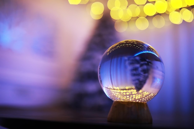 Foto bola de cristal en el suelo con luces bokeh detrás bola de cristal con colorido concepto de celebración de año nuevo de luz bokeh