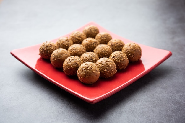 Bola de açúcar mascavo de semente de gergelim ou til ke laddo e tilgul ou til gul laddu servidos em uma tigela para o Festival Makar Sankranti na Índia