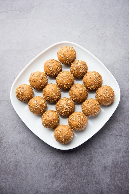 Bola de açúcar mascavo de semente de gergelim ou til ke laddo e tilgul ou til gul laddu servidos em uma tigela para o Festival Makar Sankranti na Índia