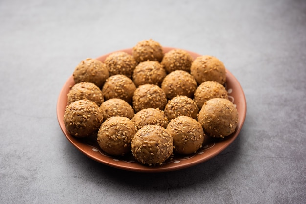 Bola de açúcar mascavo de semente de gergelim ou til ke laddo e tilgul ou til gul laddu servidos em uma tigela para o Festival Makar Sankranti na Índia