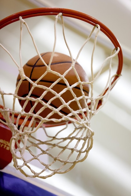 Foto bola de basquete caindo na rede no fundo do ginásio