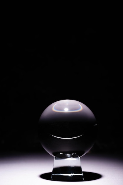 Foto bola de cristal na superfície branca no fundo preto
