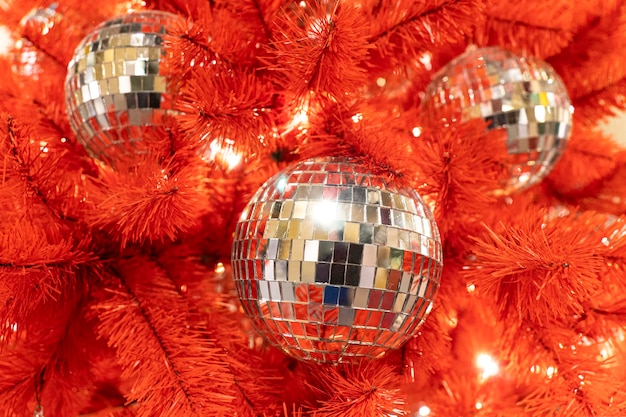 Bola de discoteca de natal com um laço vermelho na árvore de natal fundo de ano novo árvore de natal decorada