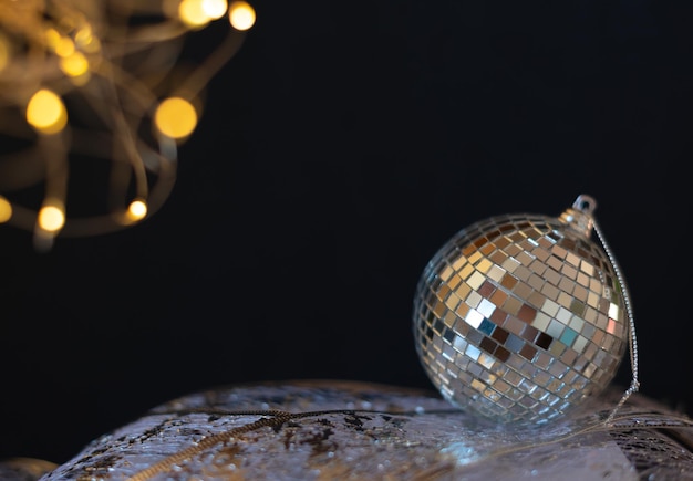 Bola de espelho de discoteca prata bola de Natal close-up com foco seletivo contra fundo preto Natal ou conceito de celebração de férias de inverno cartão de saudação de ano novo com espaço de cópia para o texto