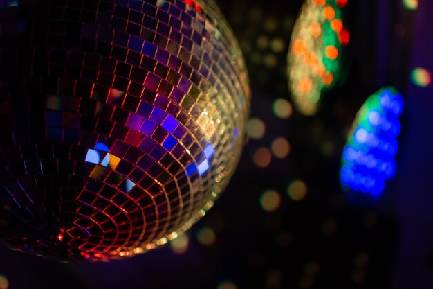 Bola de espelhos de discoteca de festa refletindo luzes roxas.