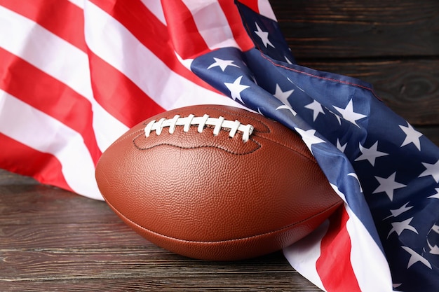 Foto bola de futebol americano e bandeira americana em fundo de madeira