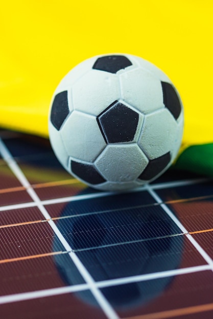 Bola de futebol e bandeira do Brasil sobre painel solar fotovoltaico Copa do Mundo e imagem de conceito de tecnologia para Design