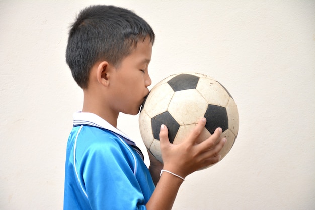 Bola de futebol nas mãos de um menino asiático