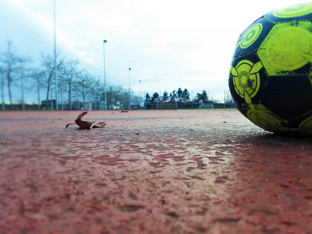 Foto bola de futebol no campo contra o céu nublado