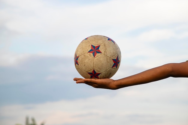 Foto bola de futebol suja velha na mão