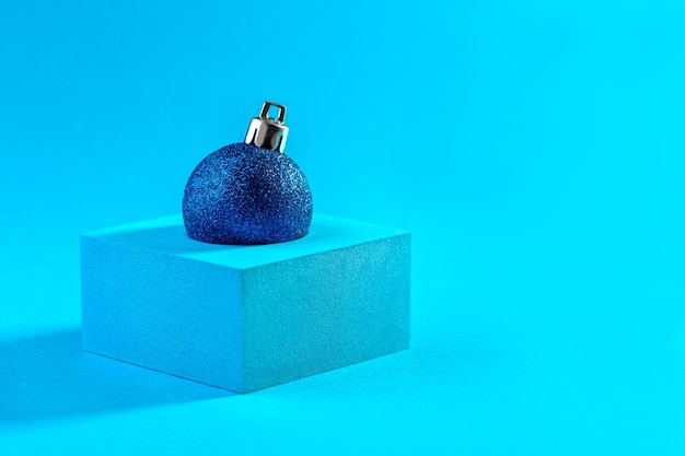 Bola de glitter azul de Natal no pódio em azul