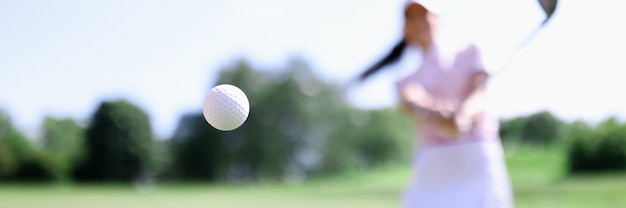 Bola de golfe contra o fundo de uma mulher atingida.