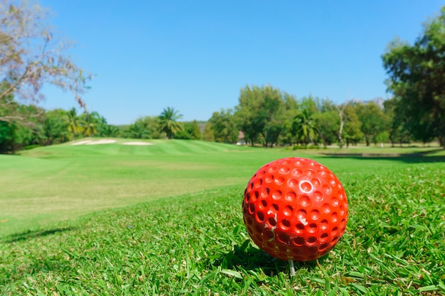 Foto bola de golfe vermelha em campo verde
