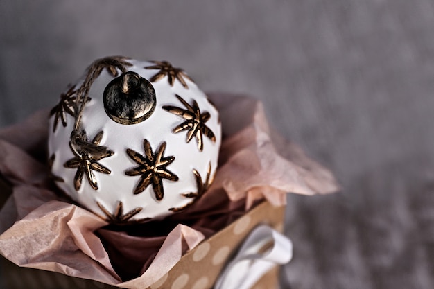 Bola de natal branco sentado na caixa de presente, férias de inverno