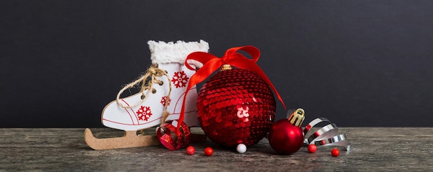 Bola de Natal com patins em bugiganga de decoração de fundo colorido com laço de fita com espaço de cópia