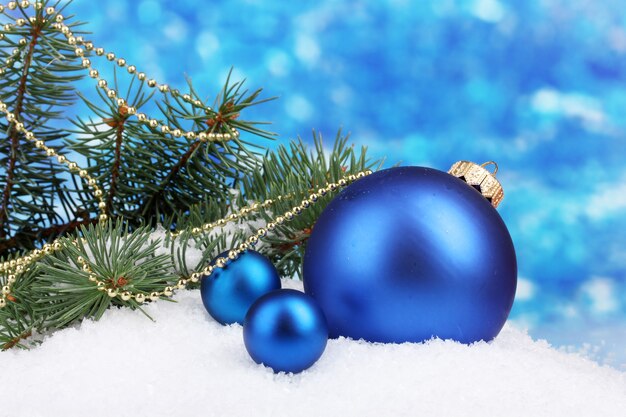 Bola de natal e árvore verde na neve em azul