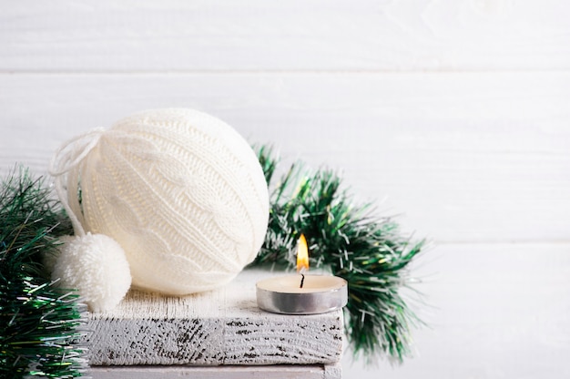 Bola de Natal em malha branca e decoração com vela acesa em interior escandinavo branco