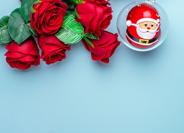 Bola de Natal em rosas vermelhas e Papai Noel próximo
