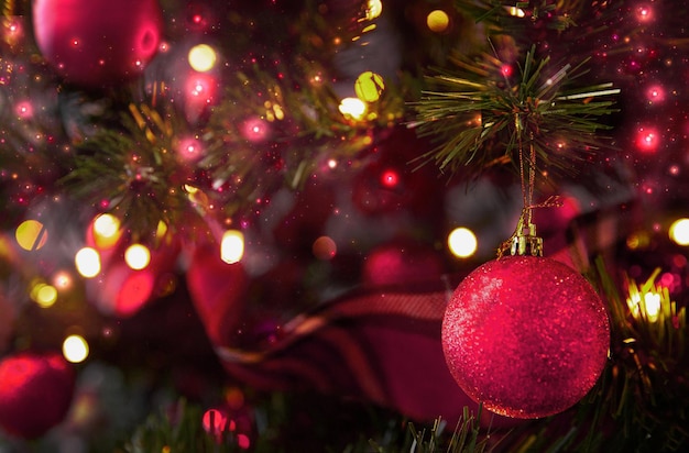Bola de Natal em uma árvore de Natal decorada com uma guirlanda de luzes Cor de 2023 Viva Magenta