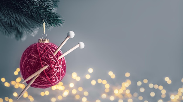 Bola de natal viva magenta na forma de uma bola de fios com raios na árvore de natal