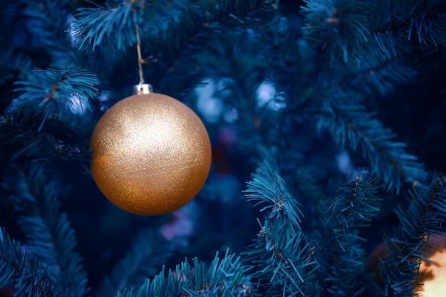 Bola de ouro na árvore do ano novo. decorações de natal para o feriado.