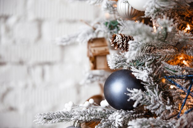 Foto bola de prata de brinquedo de natal pendurado em uma árvore de natal