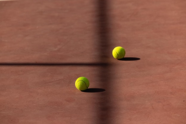 Bola de tênis na quadra de saibro dois separados por sombra