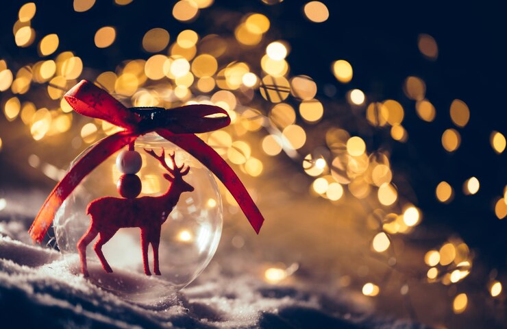 Foto bola de vidro de natal com uma rena dentro sobre fundo de brilho de luzes de neve