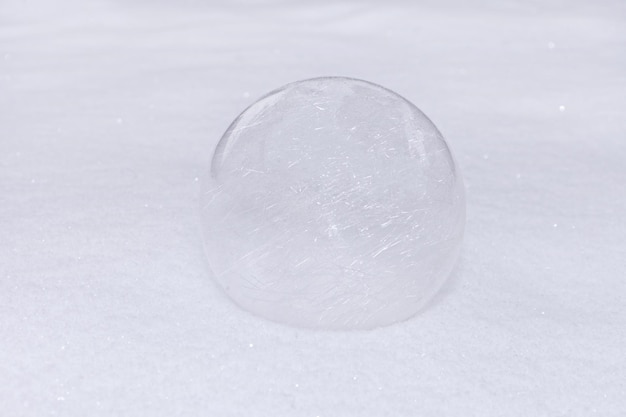 Bola de vidro ou bugiganga transparente na neve branca inverno ao ar livre esfera fundo nevado