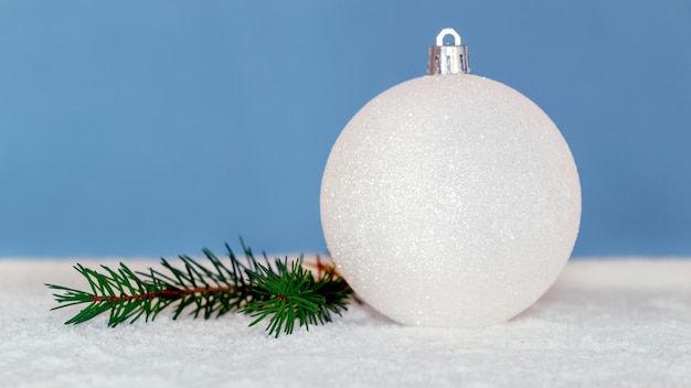 Foto bola de white christmas e galho de árvore de natal