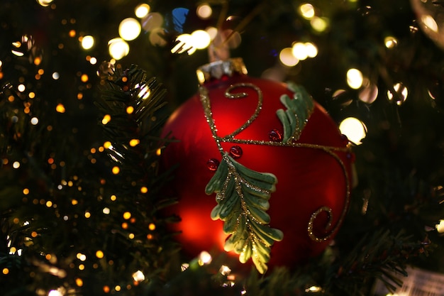 Bola decorativa vermelha na árvore de Natal Guirlanda cintilante no fundo