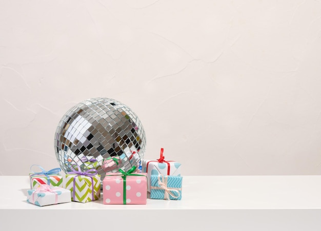 Una bola de discoteca brillante y muchos regalos de cumpleaños diferentes Fiesta en el club Copiar espacio para el texto