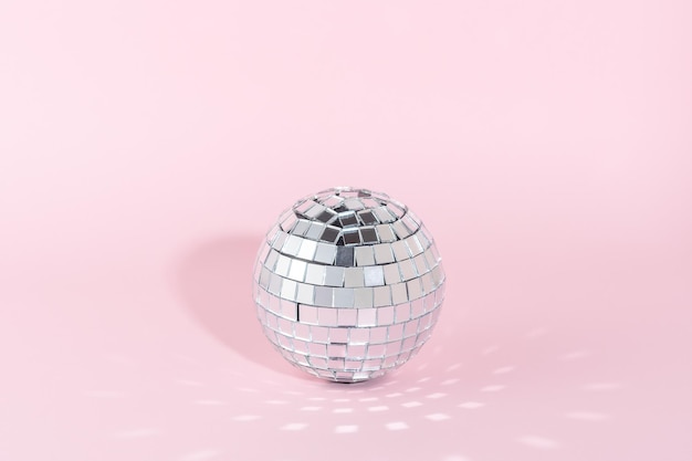 Foto bola de discoteca brillante sobre fondo rosa concepto mínimo de fiesta