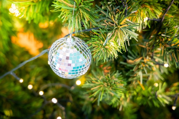 bola de discoteca colgando en el árbol de navidad decorado