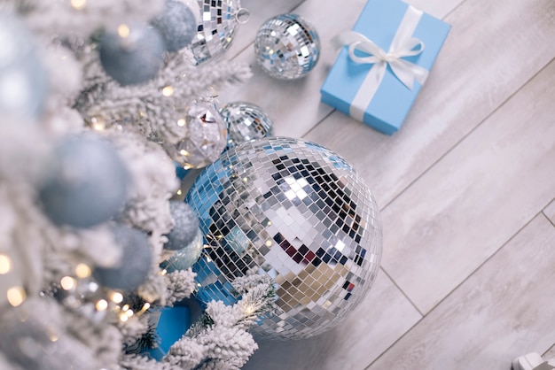 Foto bola de discoteca y regalos se encuentran debajo del árbol de navidad