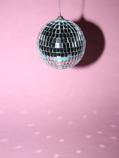 Bola de discoteca sobre un fondo rosa brillante Concepto de fiesta minimalista