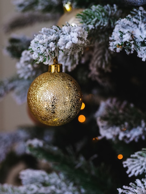 Bola dourada brilhante na árvore de natal de perto