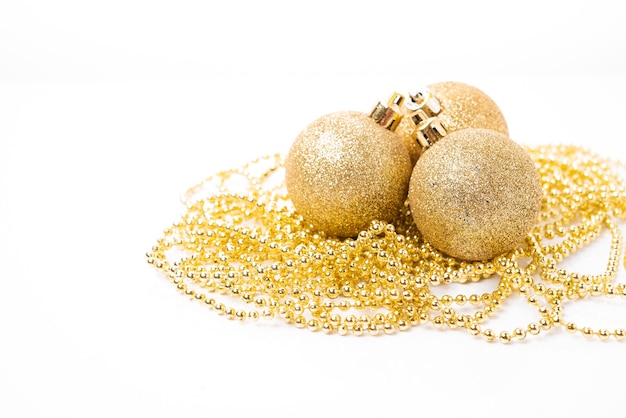 Foto bola dourada de natal para decoração da árvore de natal e decorações do feriado em fundo branco, brinquedos de natal, espaço de cópia