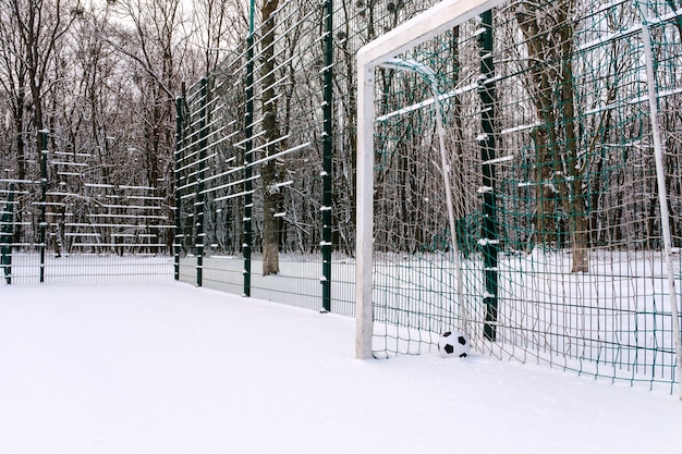 Bola en la esquina de la portería de fútbol en invierno