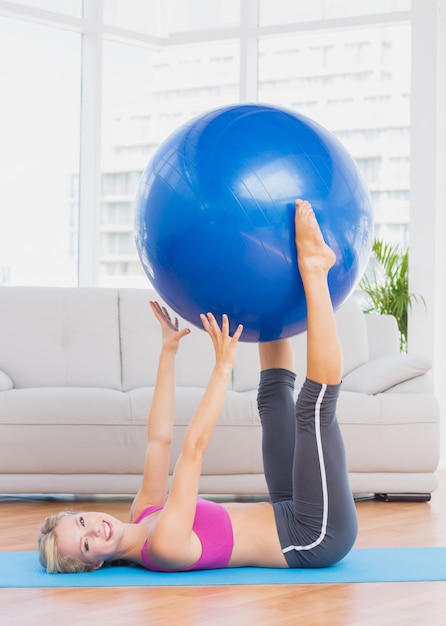 Bola feliz de exercícios de loira com as pernas