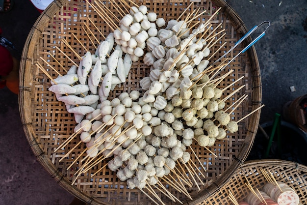 Bola fervida com palitos, comida ao estilo tailandês. Fast food de rua na Tailândia, close-up