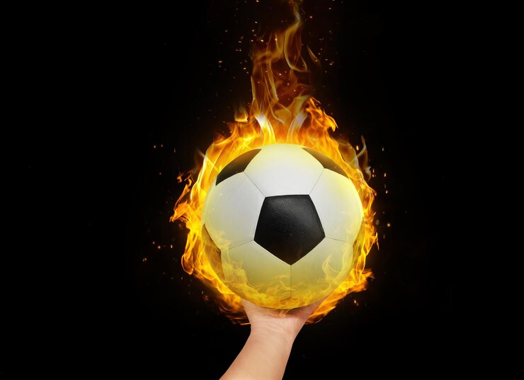 Bola de fútbol en la mano con llamas ardientes