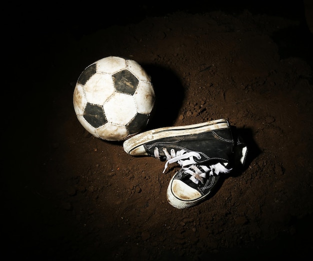 Foto bola de fútbol en el suelo sobre un fondo oscuro