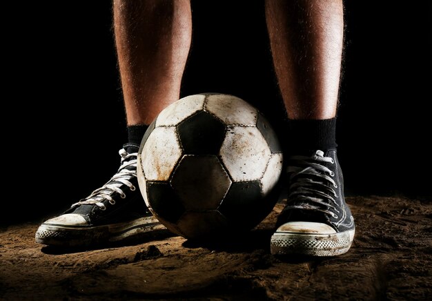 Foto bola de fútbol en el suelo sobre un fondo oscuro