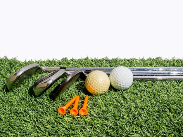 Bola de golf y club en el césped contra un fondo blanco