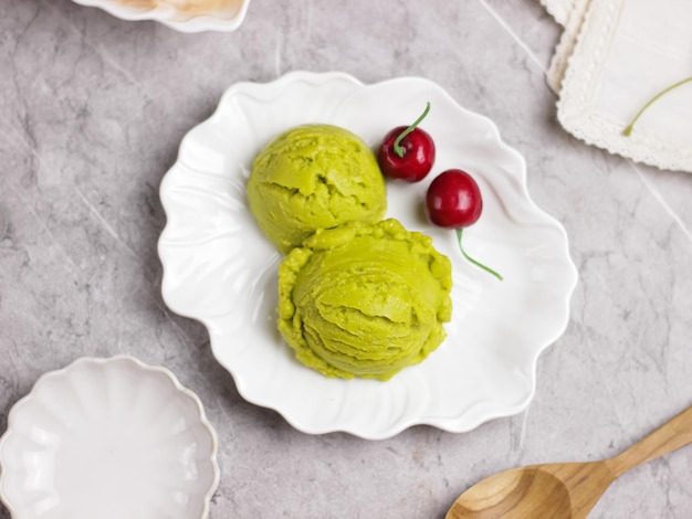 Bola de helado de aguacate servida en un plato blanco