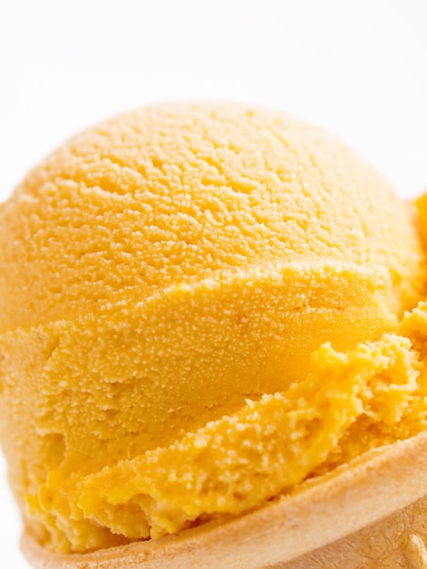 Bola de helado de calabaza gourmet en cono de pastel sobre fondo blanco.