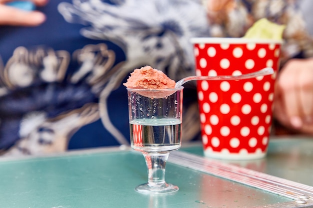 La bola de helado se encuentra en una cuchara transparente sobre un vaso