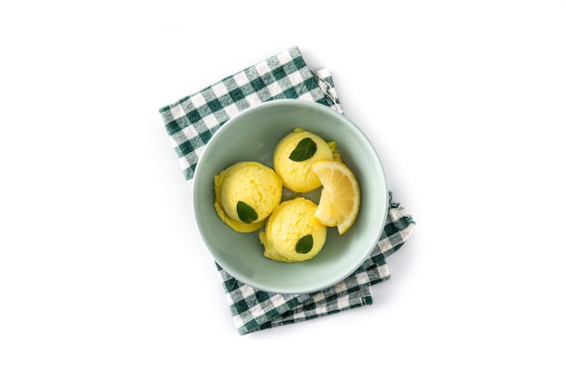 Bola de helado de limón decorada con hojas de menta en un tazón aislado